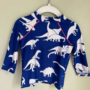 Mini Boden boys rashguard. Royal blue background with ivory dinosaurs .Size 2/3